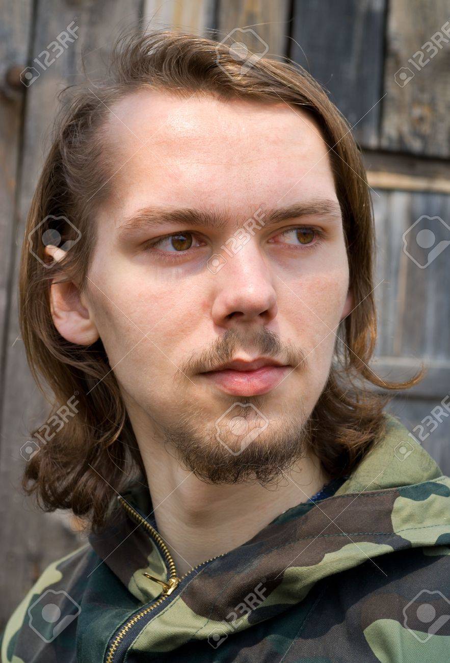 A Portrait Close Up Of The Young Man With Long Hair And Small