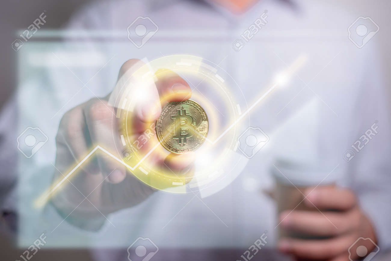 가상 그래프 그래픽이 있는 금 비트코인을 들고 있는 사업가의 손. 비트코인, 디지털 화폐 투자 개념, 블록체인 전송으로 돈을 버십시오.  로열티 무료 사진, 그림, 이미지 그리고 스톡포토그래피. Image 188433161
