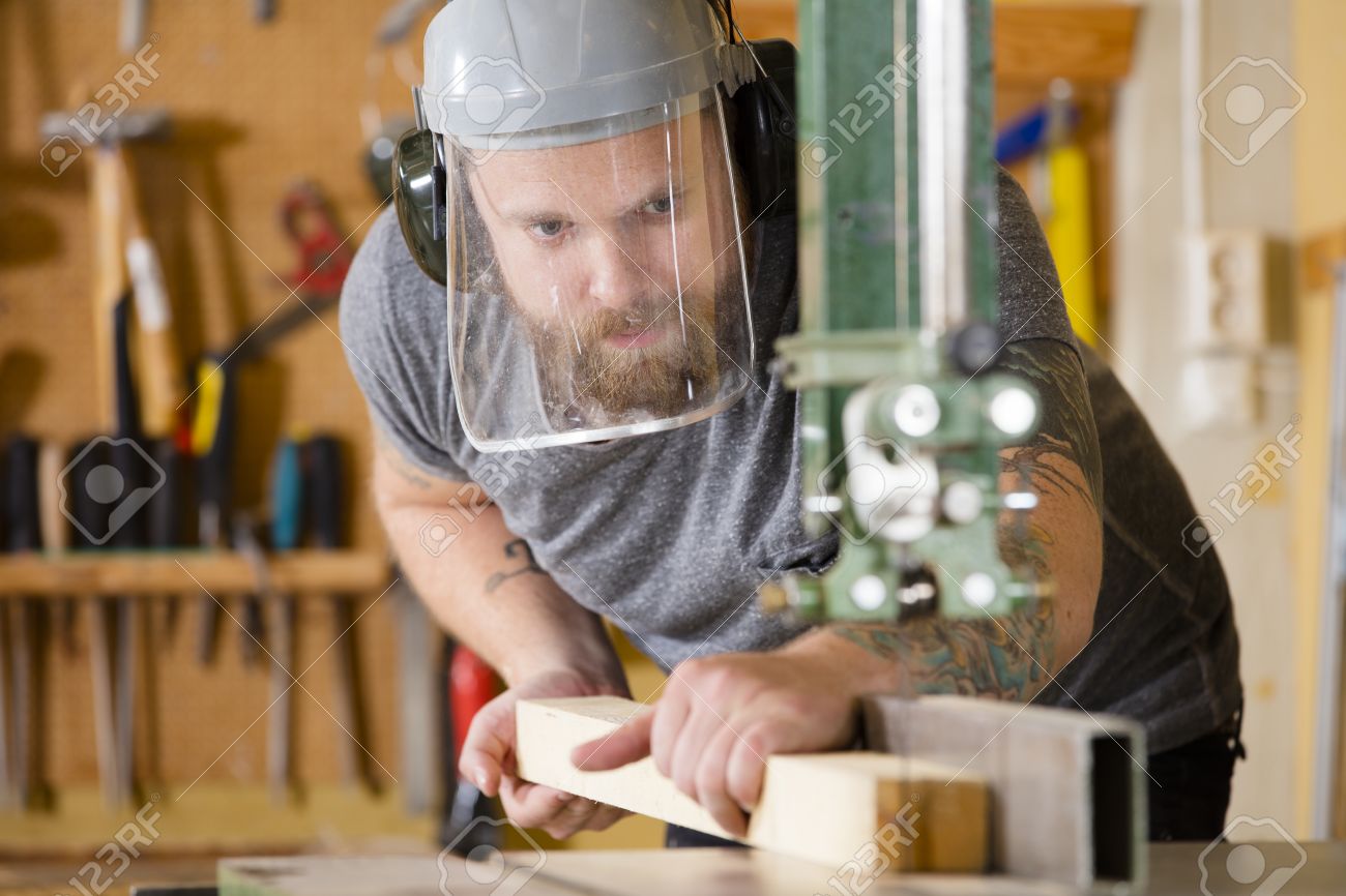 Carpintero Que Usa La Sierra De Cinta Para Cortar Madera En Un Taller De Carpinteria El Hombre Con El Tatuaje Y La Barba Usando La Mascara De Seguridad Con Visera Fotos Retratos