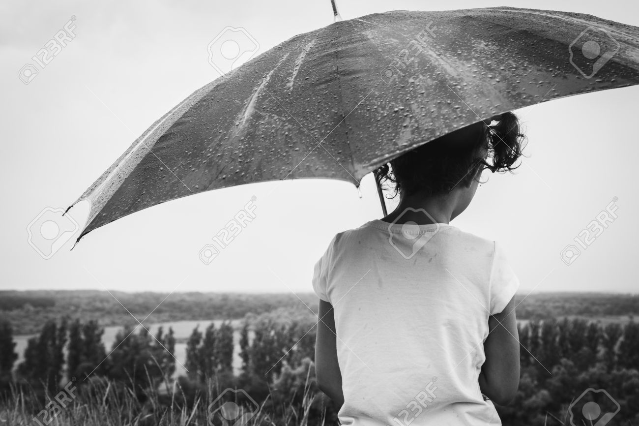 Niña Bajo La Lluvia Con Paraguas, De Espaldas A La Cámara. Imagen En Blanco Y Negro Fotos, Retratos, Y Fotografía Archivo Libres De Derecho. Image 58747716.