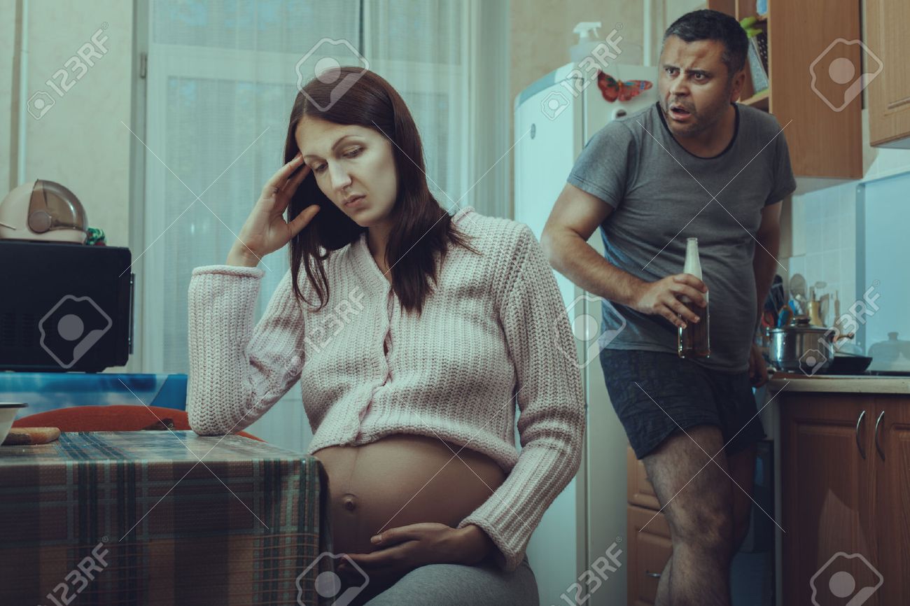 妊娠中の女性を見てのボトルと酔っぱらい 彼の顔に彼の怒り の写真素材 画像素材 Image
