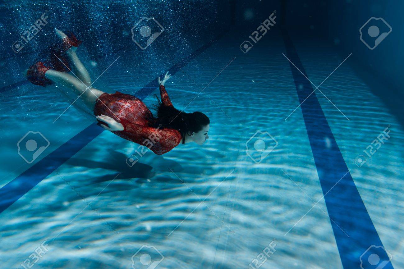 赤いドレスの女性は空気を気泡周囲水の下で潜る の写真素材 画像素材 Image