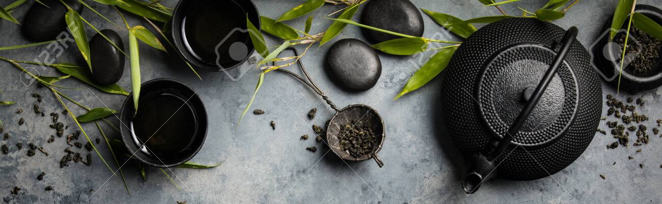 Bamboo branches and green tea on concrete background - 129350036 Bamboo branches and green tea on concrete background - 129350036