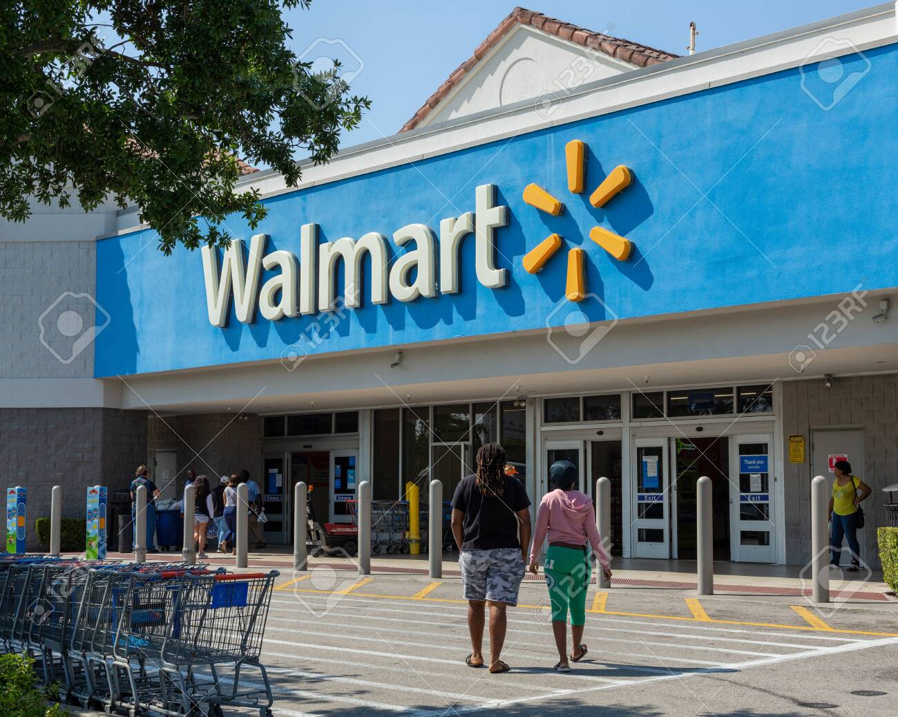 Miami, FL, USA - March 26, 2020: People Going In A Walmart Store On Sunny Day. Walmart Is The World's Third Largest Public Corporation That Runs Chains Of Department Stores. Quarantine Due