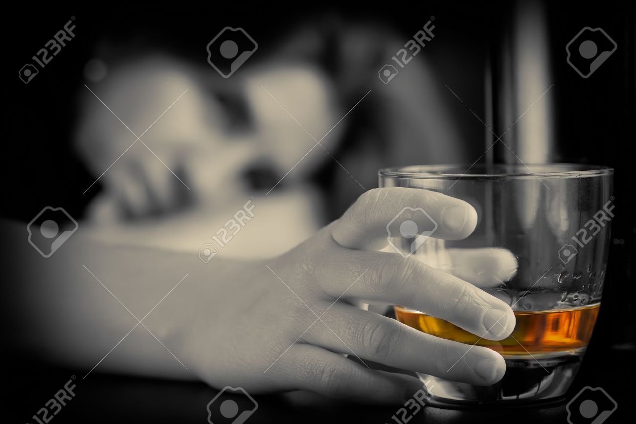 Drunk and depressed lonely woman holding a glass of whisky with a sad expression - 54766792 Drunk and depressed lonely woman holding a glass of whisky with a sad expression - 54766792