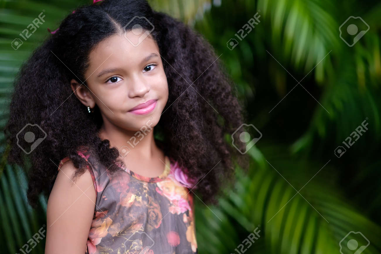 Portrait of a cute multiracial small girl with a green vegetation background - 159499002 Portrait of a cute multiracial small girl with a green vegetation background - 159499002