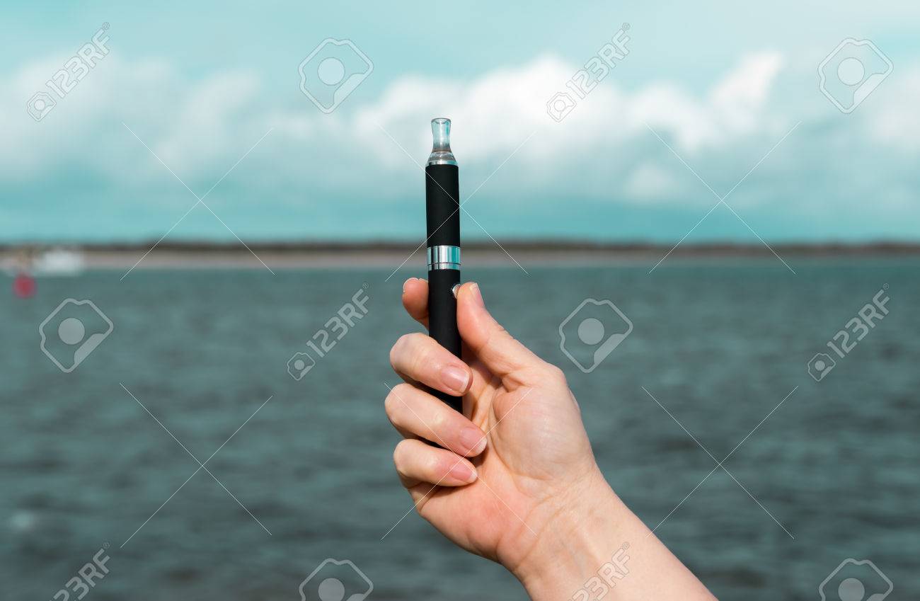 ビーチで黒の電子タバコを持っている梨花手 の写真素材 画像素材 Image