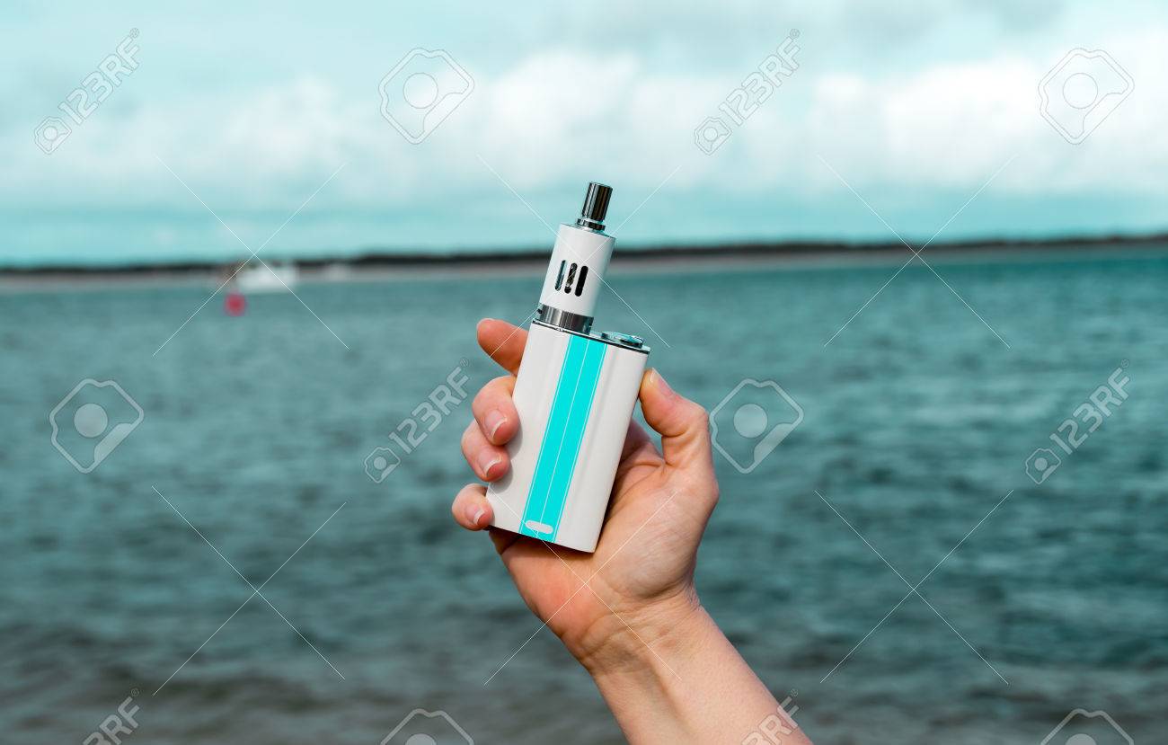 ビーチで白の電子タバコを持っている梨花手 の写真素材 画像素材 Image