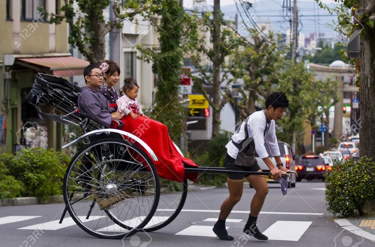 KYOTO , JAPAN - OCT 24 : Japanese family on a trditional rickshaw being pulled by a man on October 24 2009 in Kyoto , Japan - 11314555 KYOTO , JAPAN - OCT 24 : Japanese family on a trditional rickshaw being pulled by a man on October 24 2009 in Kyoto , Japan - 11314555