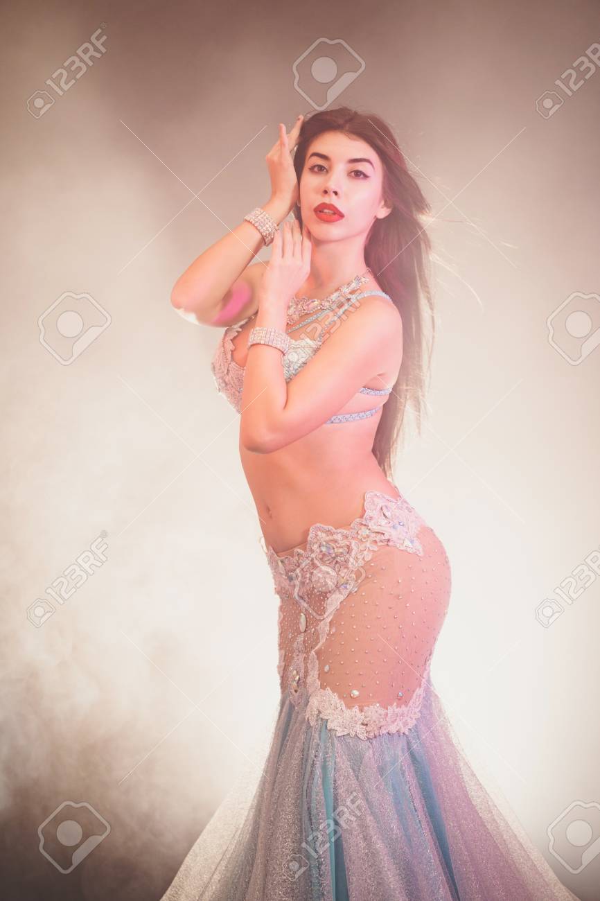 イスラム　ヌード 性的に半ヌードボディを装ったエキゾチックな衣装を着た女性の肖像画。青い輝く背景にセクシーな伝統的な東洋のベリーダンサーの女の子。イスラム教徒、誘惑の概念。の写真素材・画像素材  Image 109405316