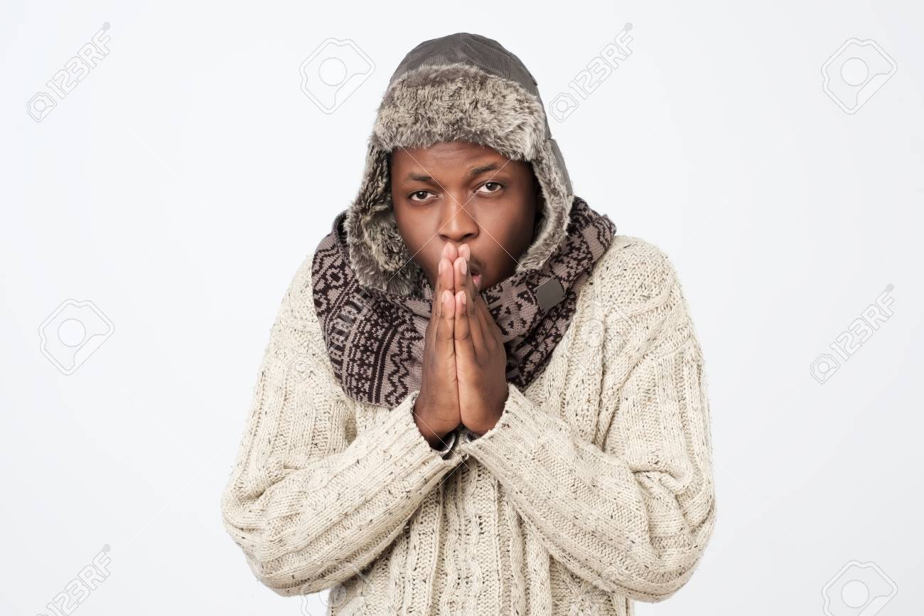 African American Man Wearing Winter Clothing But Feeling Cold In A White  Background Stock Photo, Picture and Royalty Free Image. Image 111170442.
