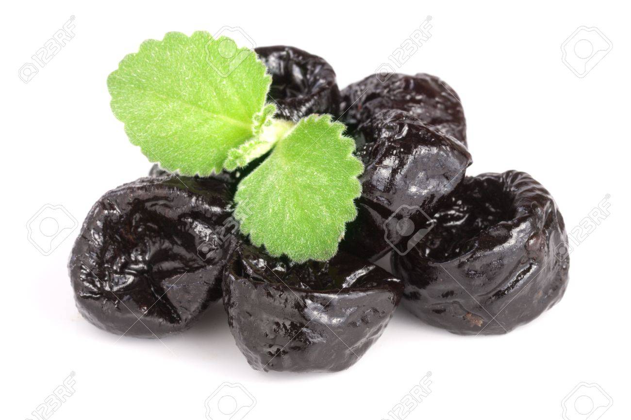 heap of dried plums or prunes with a mint leaf isolated on white background. - 83068992 heap of dried plums or prunes with a mint leaf isolated on white background. - 83068992