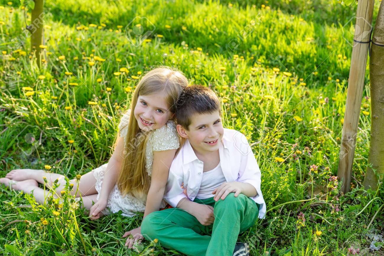 Sister and brother are resting in a blooming garden in the spring. Children have fun in the apple orchard before sunset. Beautiful happy boy and girl in the flowered garden in the rays of the setting sun - 75221721 Sister and brother are resting in a blooming garden in the spring. Children have fun in the apple orchard before sunset. Beautiful happy boy and girl in the flowered garden in the rays of the setting sun - 75221721