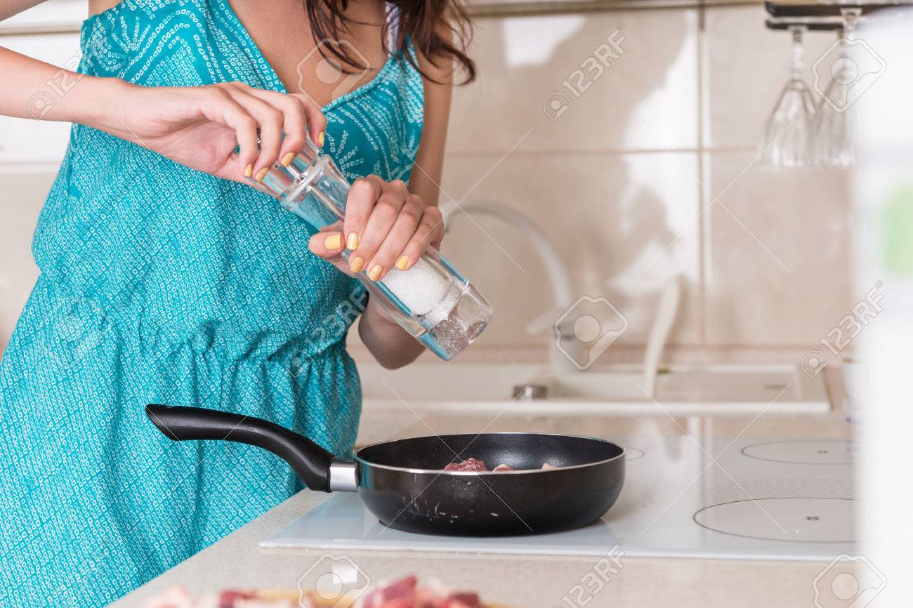 Woman Seasoning Her Cooking With Salt Using A Mill To Grind Rock Woman Seasoning Her Cooking With Salt Using A Mill To Grind Rock