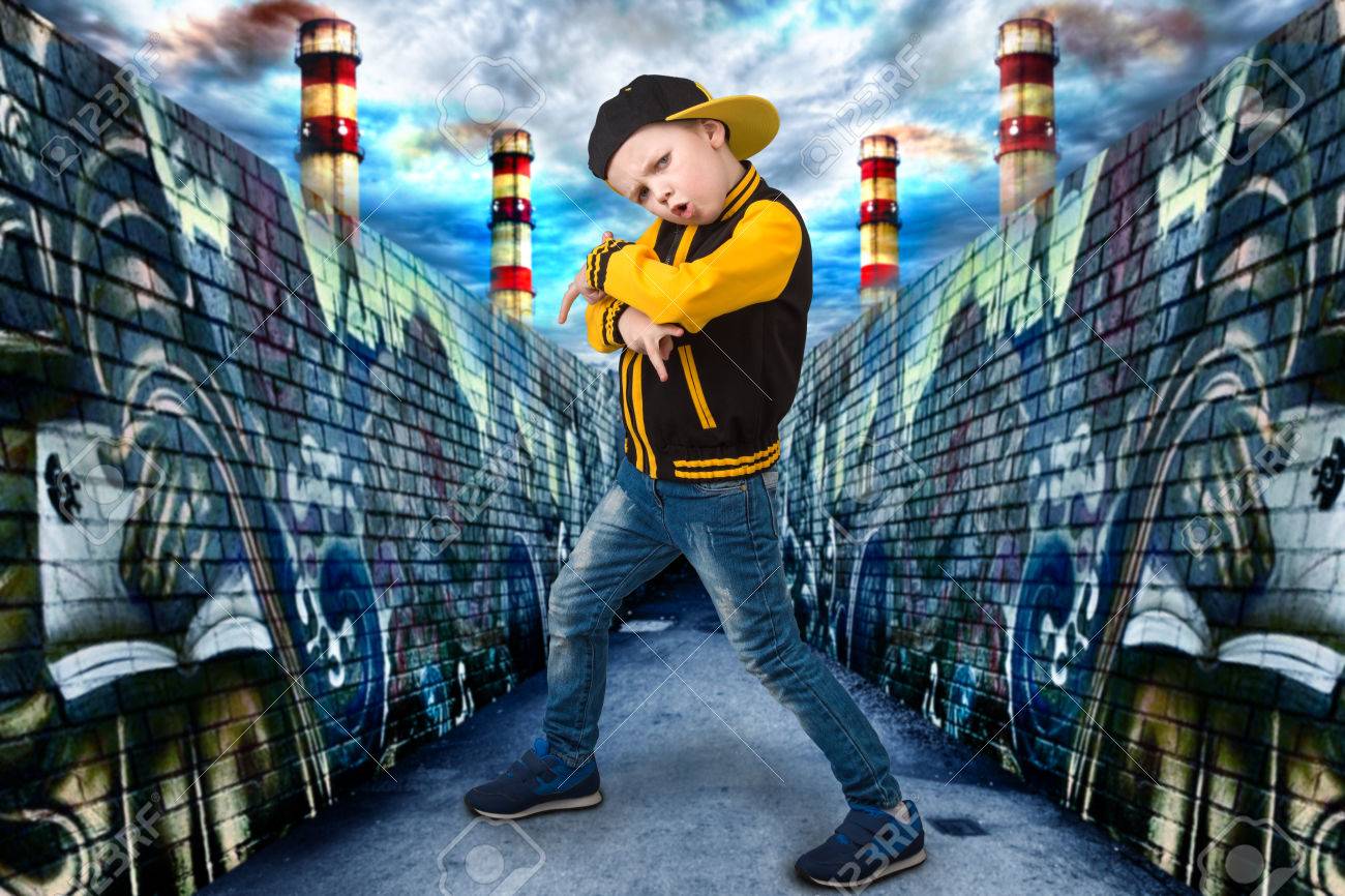 El Niño Pequeño En El Estilo De Hip-hop. Moda Para Niños.cap Y Chaqueta. Un Pequeño Rapero.grafiti En Las Paredes.cool Rap Dj. Fotos, Imágenes Y Fotografía De Archivo De Derecho. Image