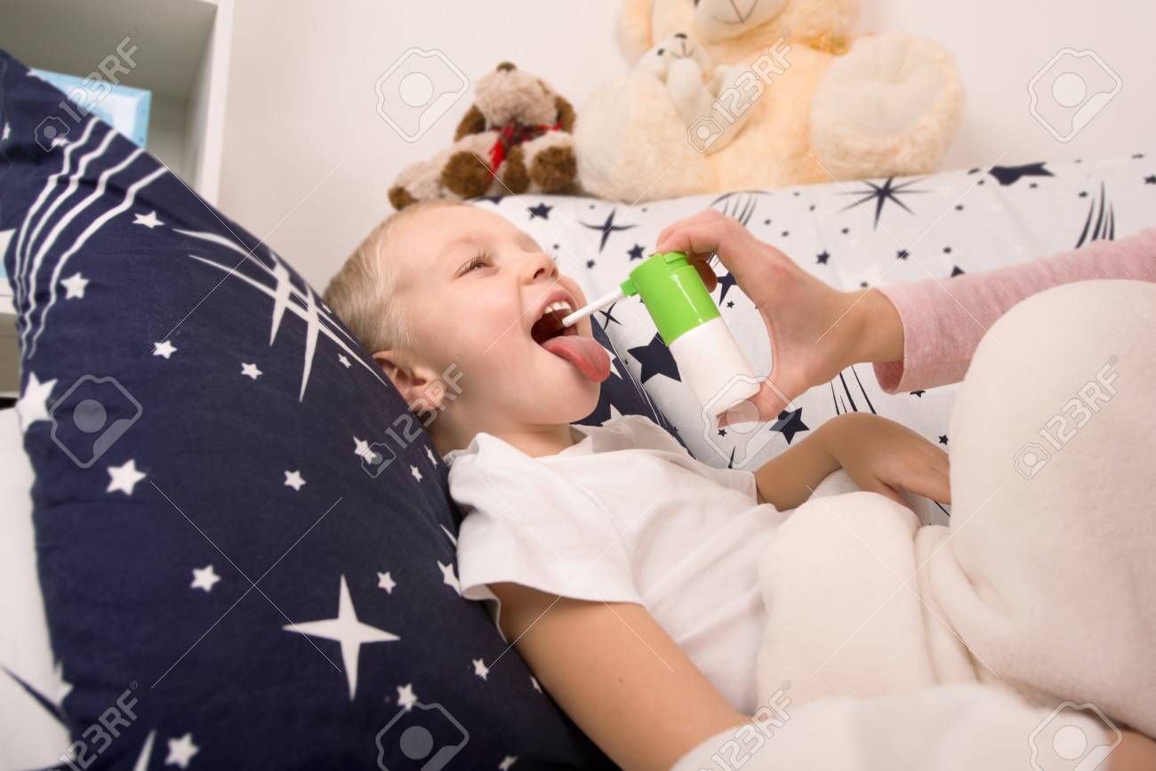 La Mere Traite Le Bebe Le Spray D Un Mal De Gorge Banque D Images Et Photos Libres De Droits Image