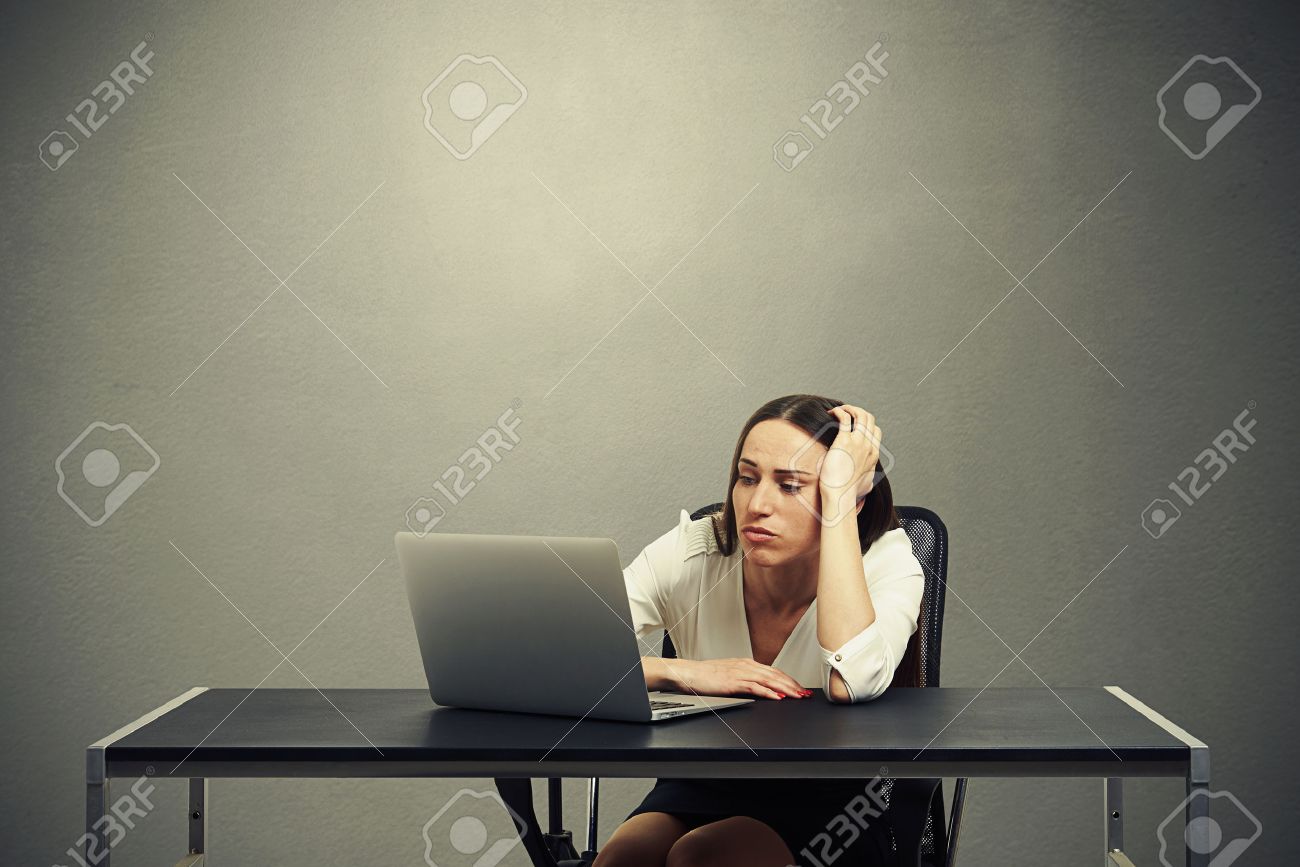 tired businesswoman looking at monitor and feeling sad over dark background - 38417137 tired businesswoman looking at monitor and feeling sad over dark background - 38417137