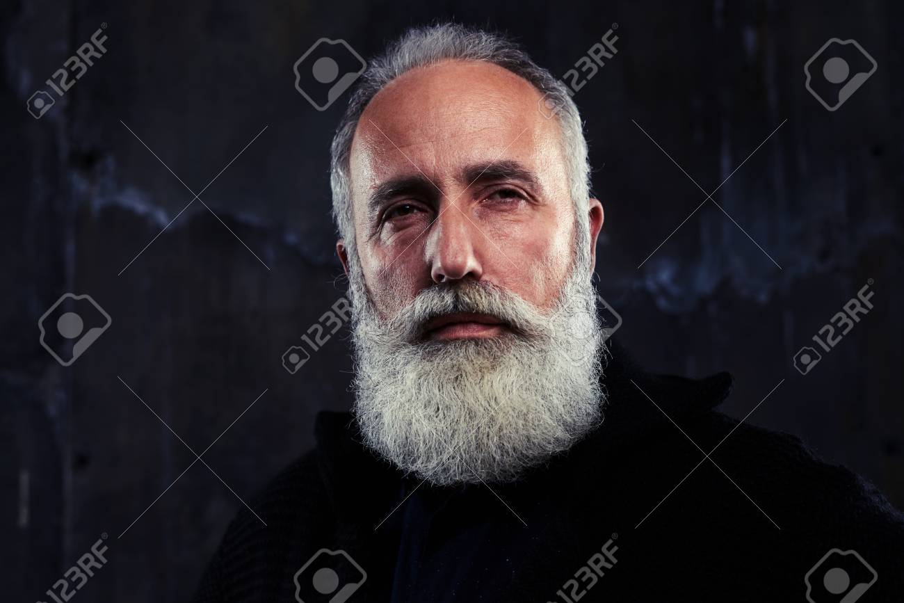 Standard Bild Studio Portrait von stilvollen bärtigen Mannes Moderne Frisur Stirnrunzeln gut aussehend bärtigen Mann Ernster Blick in Augen