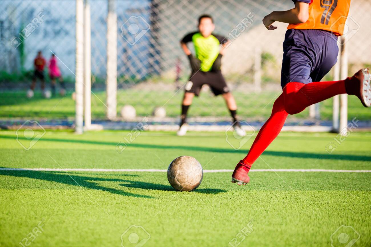 soccer player run to shoot ball at penalty kick to goal with blurry goalkeeper background, concept of making goals and protection - 120398938 soccer player run to shoot ball at penalty kick to goal with blurry goalkeeper background, concept of making goals and protection - 120398938