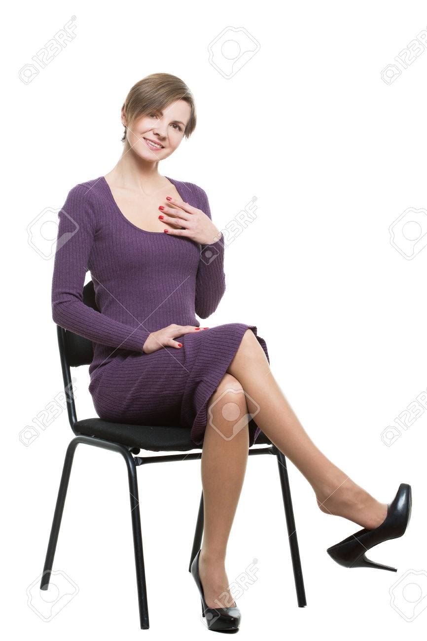 女性では 椅子に座っています ポーズは 性的欲求を示します いちゃつきます 足を組んで 靴が値下がりしました 屈曲 白い背景上に分離 ボディーラン ゲージ の写真素材 画像素材 Image