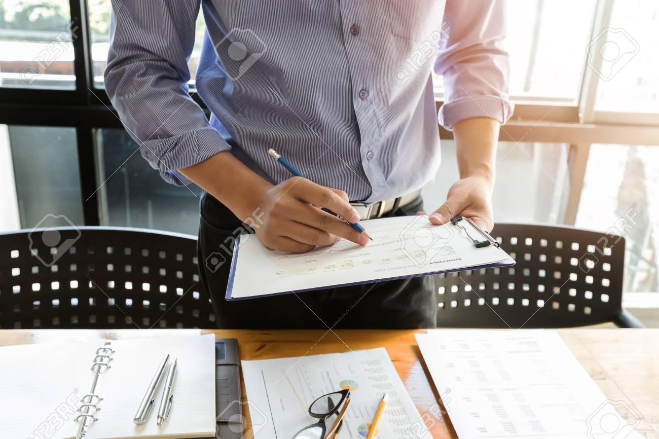 businessman analyzing a series of graphs with colleagues while meeting summaries