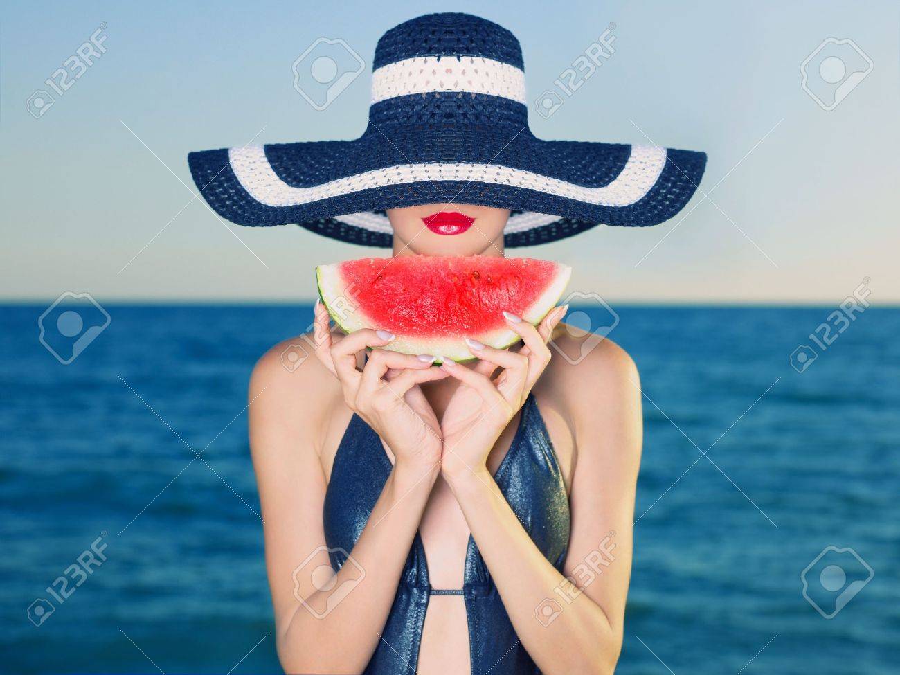 Young stylish lady in a hat at sea with watermelon - 12949677 Young stylish lady in a hat at sea with watermelon - 12949677