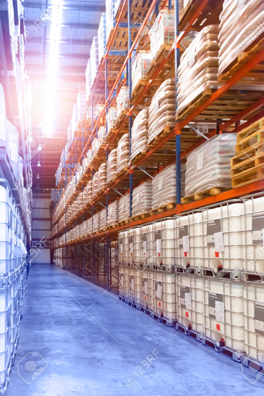 Large distribution warehouse interior, pallets and boxes of cargo stack on row of high shelves. - 149806696 Large distribution warehouse interior, pallets and boxes of cargo stack on row of high shelves. - 149806696