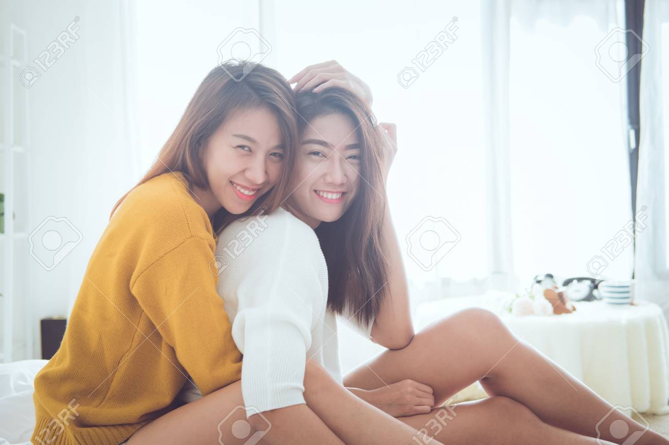 熟女　同性愛　レズビアン 素敵なレズビアンのカップル一緒にコンセプト.幸せの瞬間とベッドの上に座っている笑顔の若い女性のカップル.の写真素材・画像素材 Image  89622744