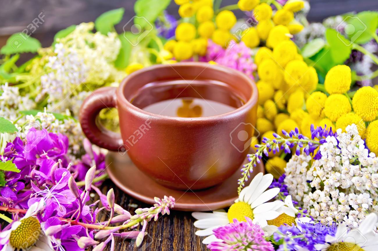 暗い木の板粘土カップ新鮮な花 Fireweed タンジー カモミール クローバー ノコギリソウ シモツケ ミントのハーブ茶します の写真素材 画像素材 Image 4547