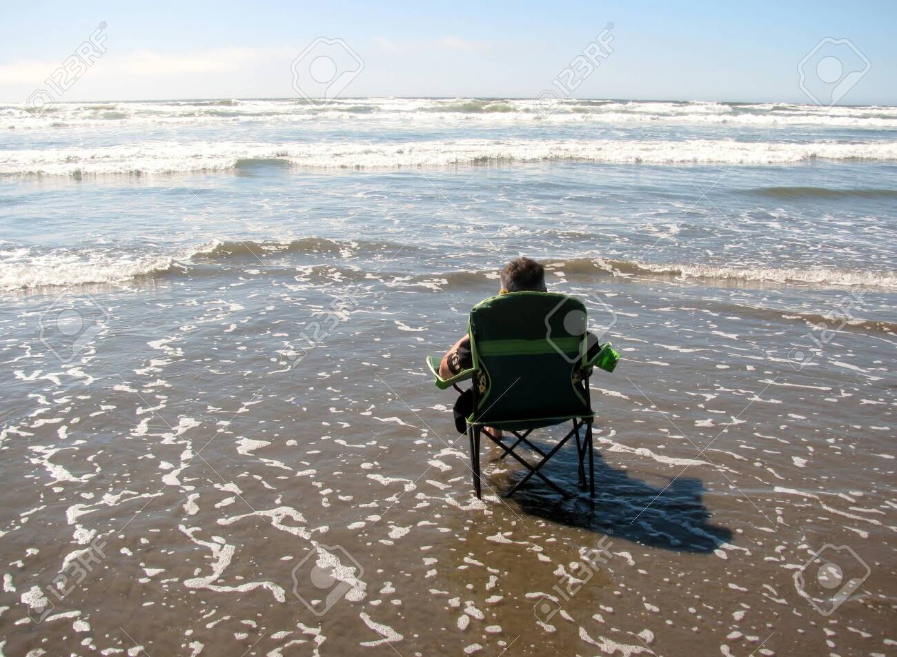 Man In A Beach Chair Standing In Water Of Tidal Waves Of Ocean Stock Photo Picture And Royalty Free Image Image 133495161