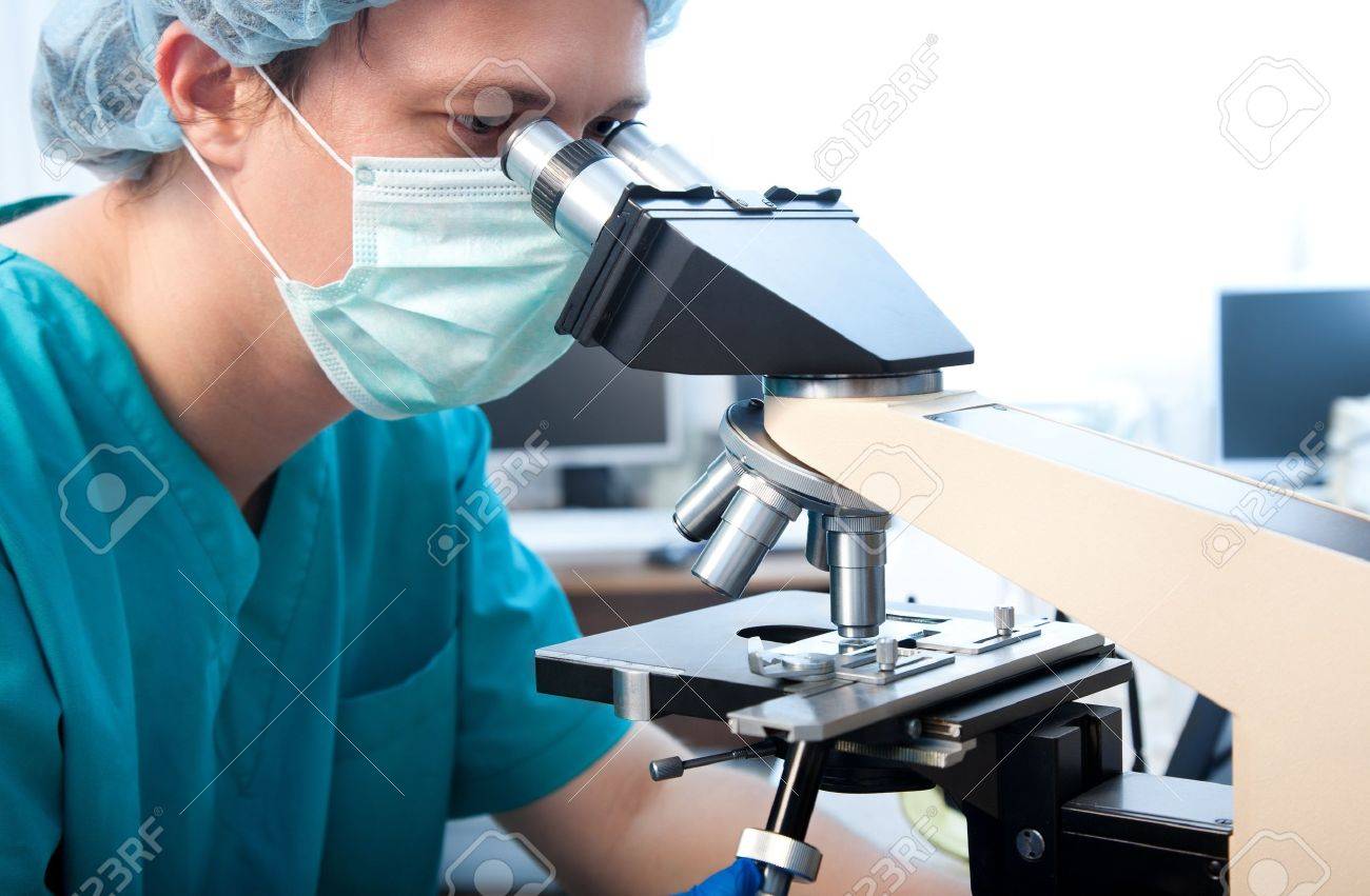 male researcher looking through microscope in laboratory - 11230901 male researcher looking through microscope in laboratory - 11230901