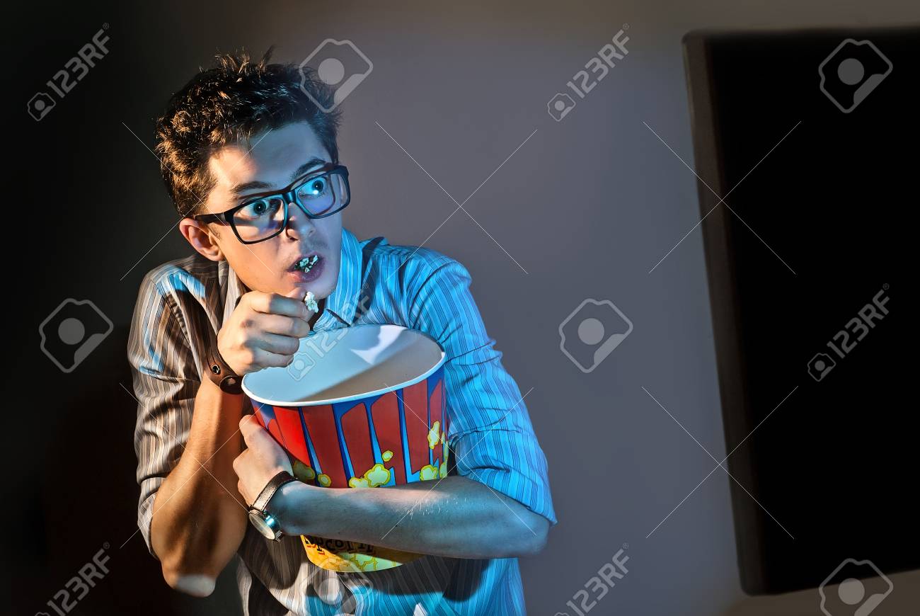 男のグラスで一人で映画を見るし ポップコーンを食べる の写真素材 画像素材 Image 89017544