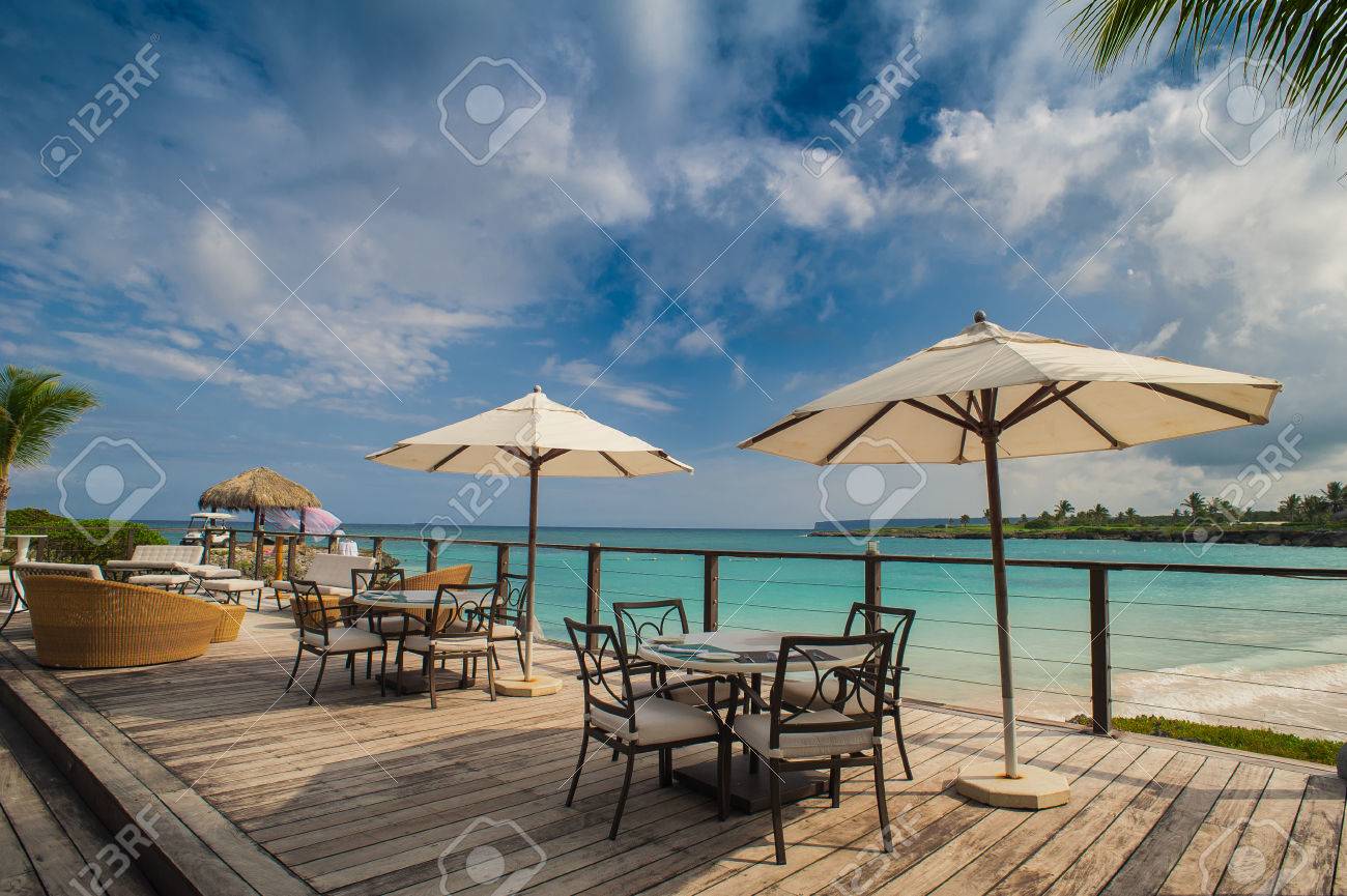 Outdoor restaurant at the beach. Cafe on the beach, ocean and sky. Table setting at tropical beach restaurant. Dominican Republic, Seychelles, Caribbean, Bahamas. Relaxing on remote Paradise beach. - 39002777 Outdoor restaurant at the beach. Cafe on the beach, ocean and sky. Table setting at tropical beach restaurant. Dominican Republic, Seychelles, Caribbean, Bahamas. Relaxing on remote Paradise beach. - 39002777