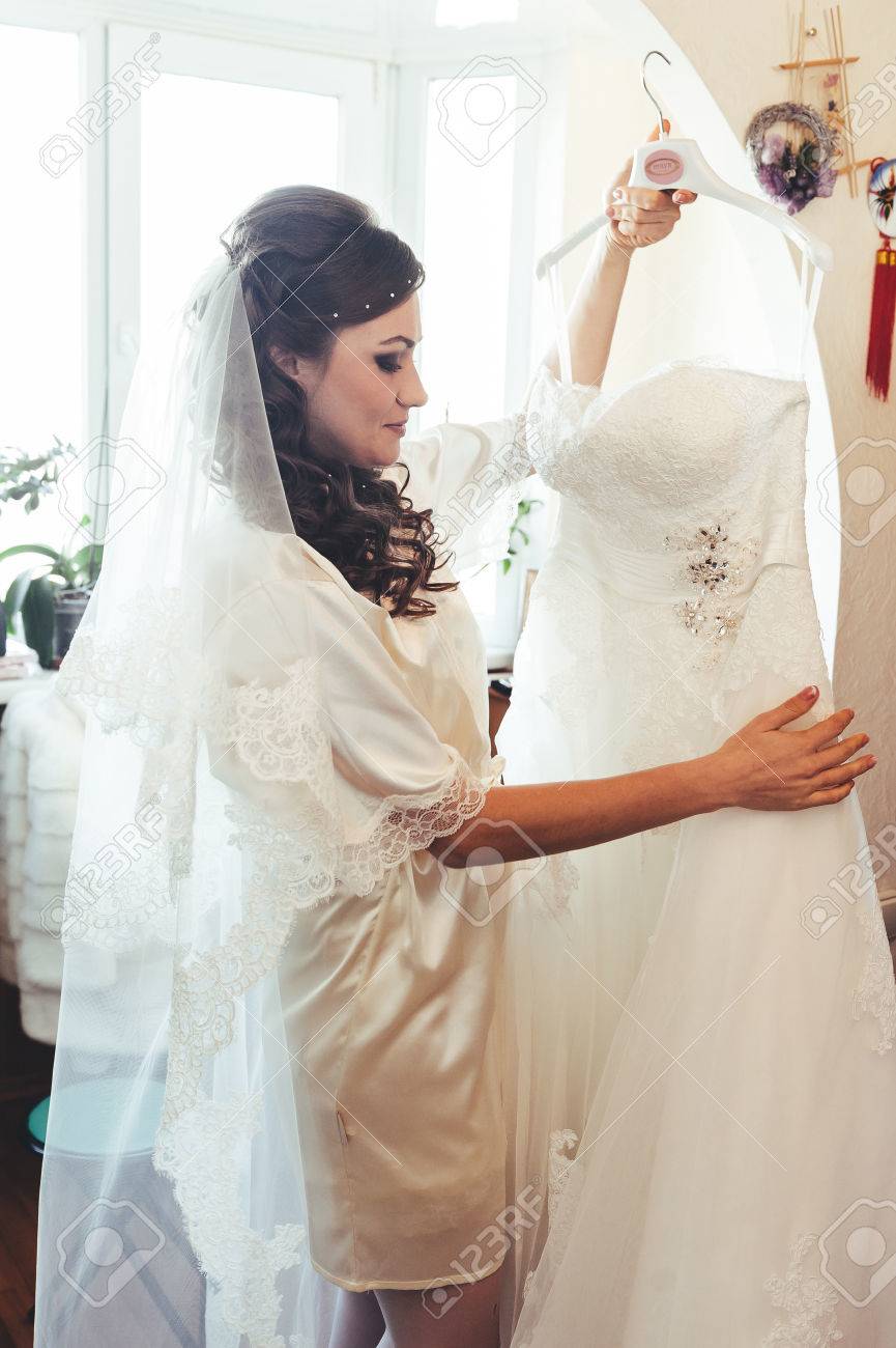 Bride Tries On A Wedding Dress Dressing Gown. Happy Beautiful ... Bride Tries On A Wedding Dress Dressing Gown. Happy Beautiful ...