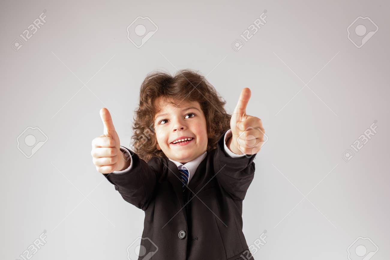 変な巻き毛の少年は 笑顔で そして 非常に良い ジェスチャーを示す 彼の腕を伸ばした 白い背景 の写真素材 画像素材 Image
