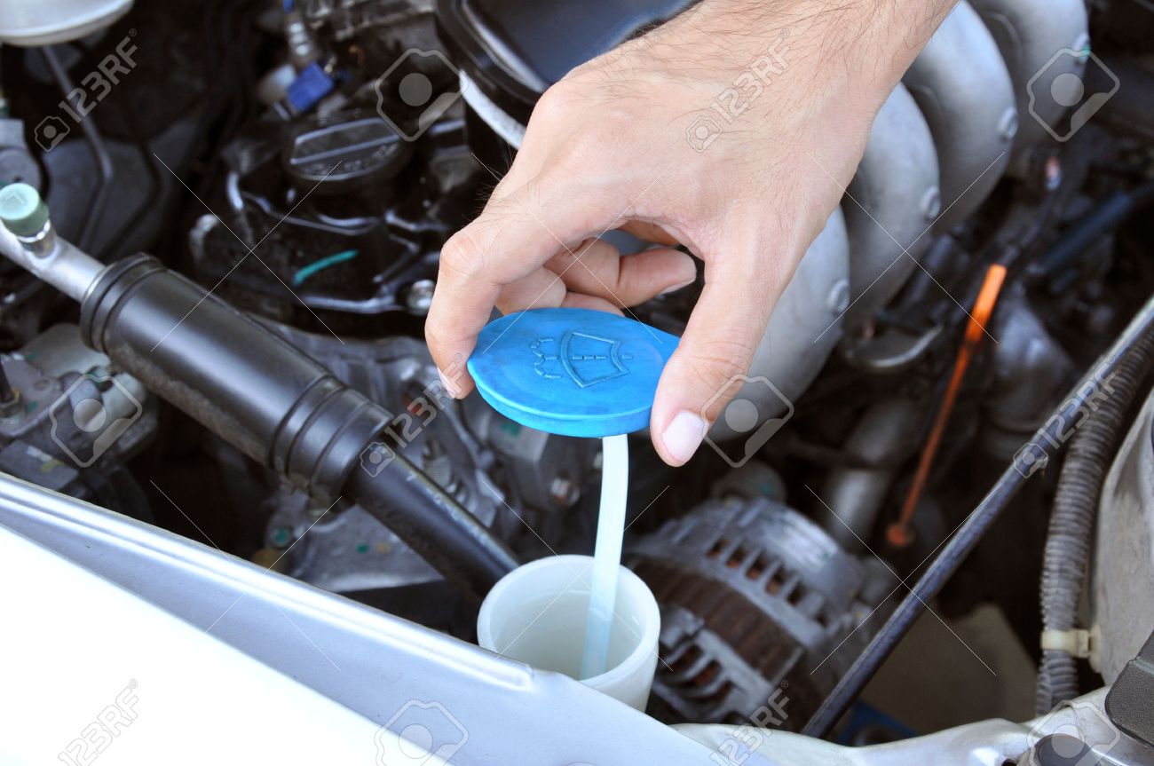 hand opening car windscreen washer tank checking water level stock water checking