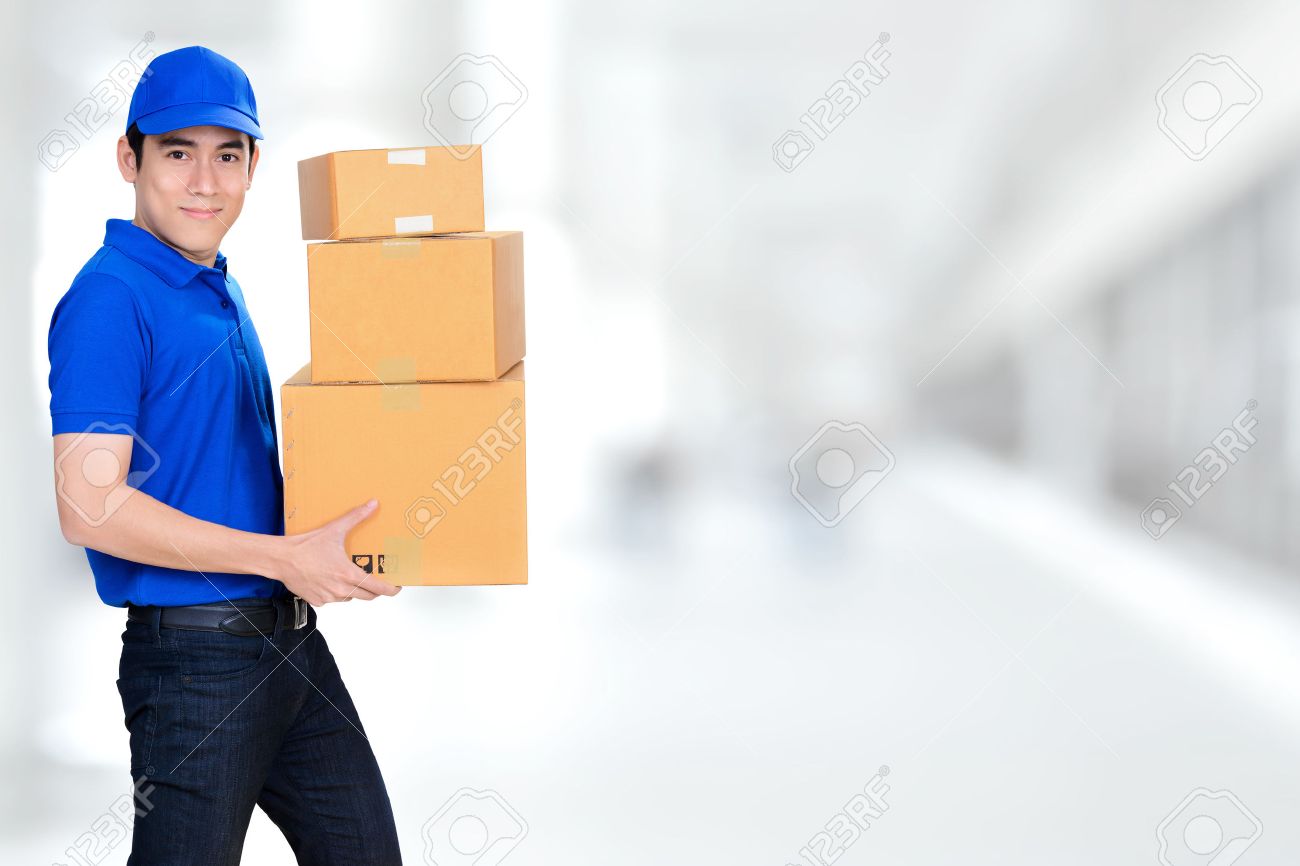 smiling friendly delivery man carrying parcel boxes on blur white