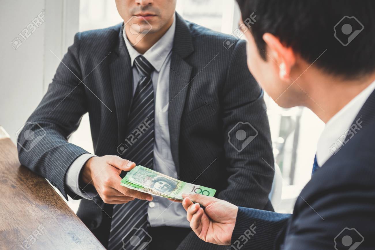 Businessman giving money, Australian dollars, to his partner - bribery and corruption concepts - 90376107 Businessman giving money, Australian dollars, to his partner - bribery and corruption concepts - 90376107