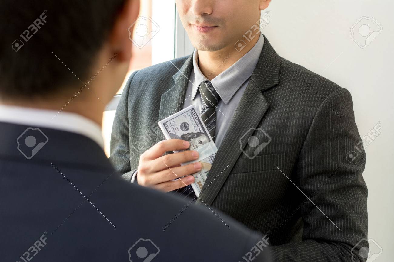 パートナーとの取り引きの後はスーツのポケットにお金を入れての実業家  