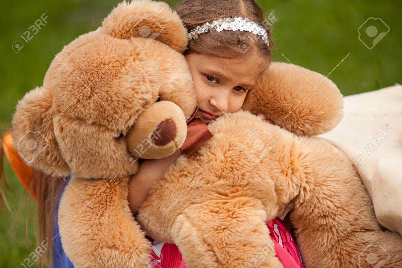 little girl hugging teddy bear