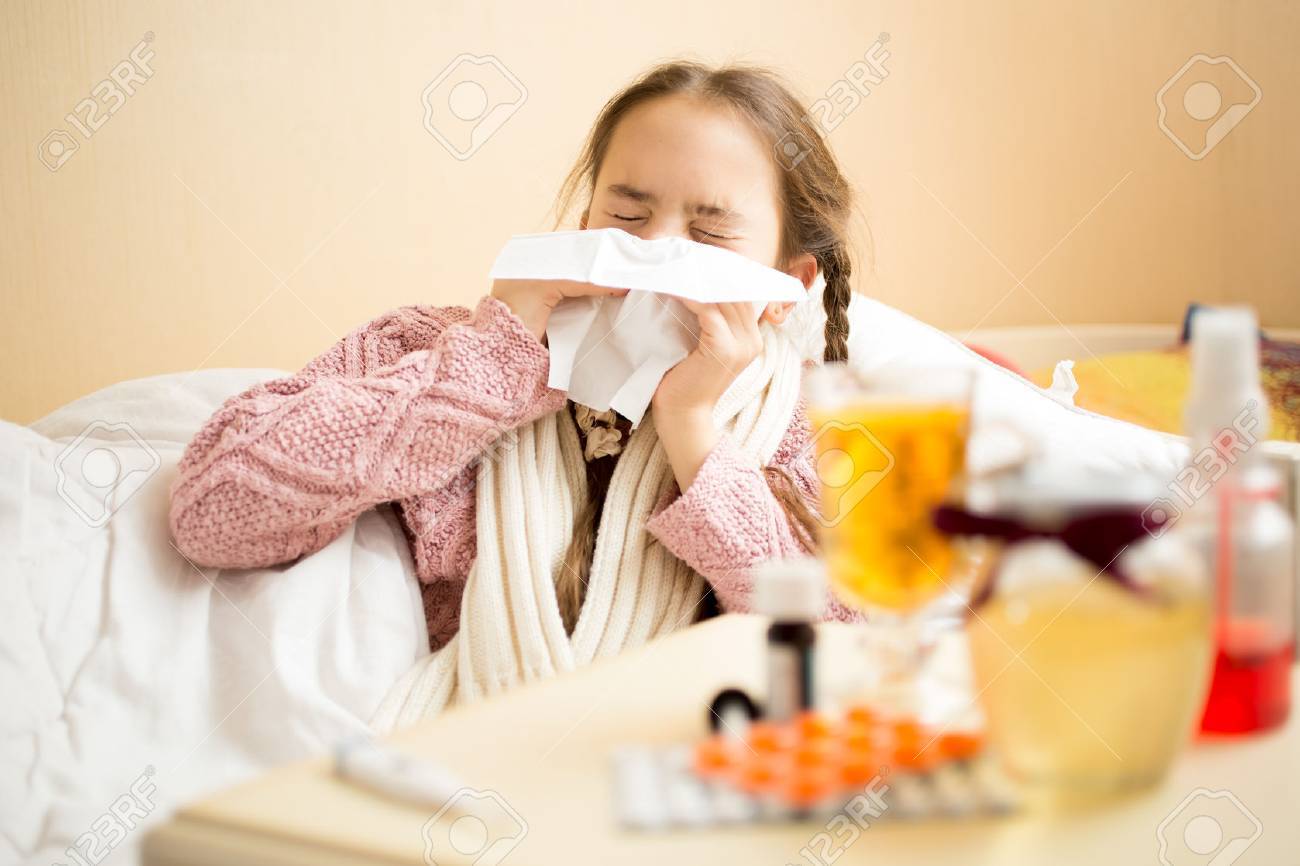 ベッドで横になっていると紙ハンカチで鼻をかむ少女の肖像画 の写真素材 画像素材 Image