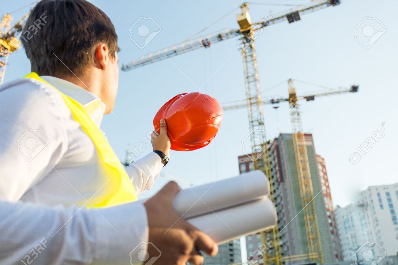 Closeup photo of engineer posing on building site with orange hardhat - 41681919 Closeup photo of engineer posing on building site with orange hardhat - 41681919