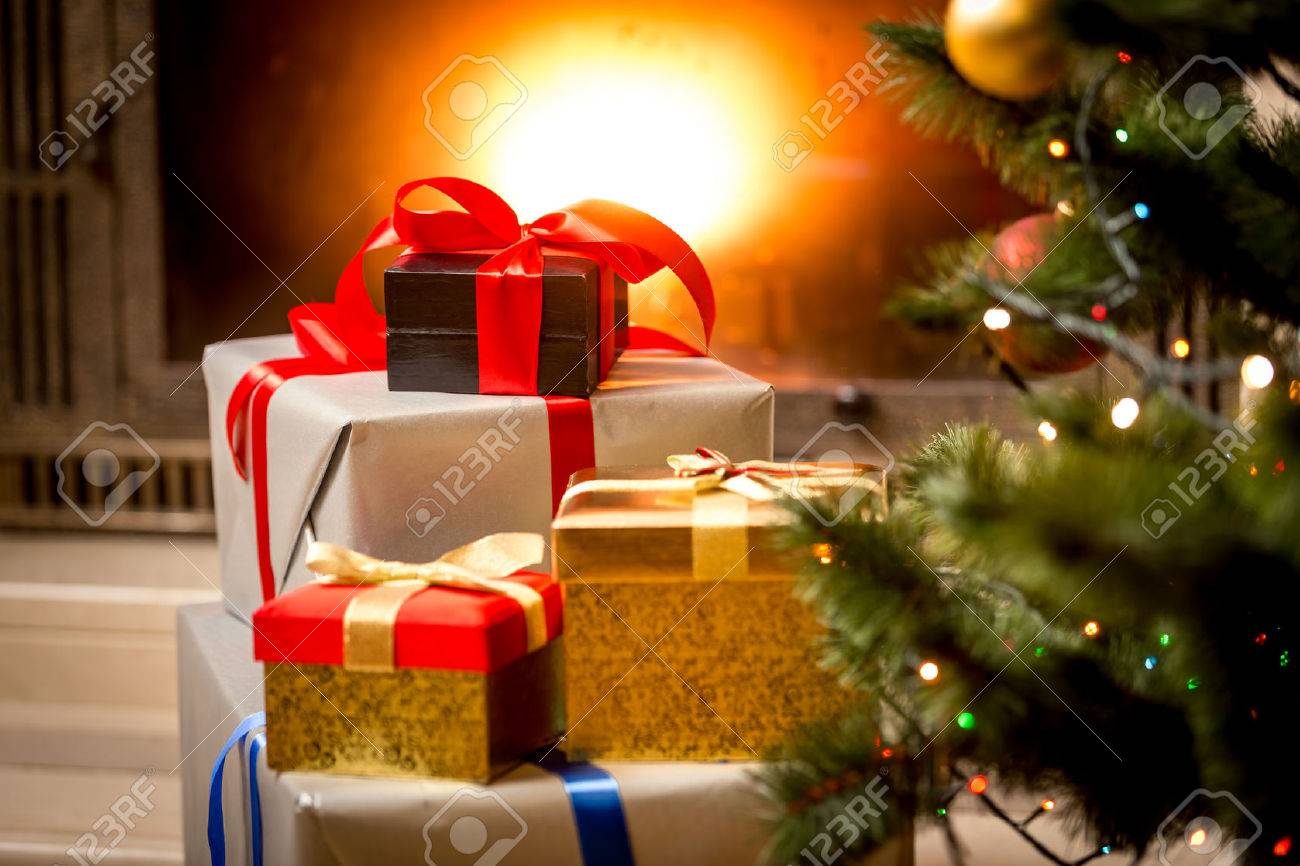 Stack of packed gift boxes under Christmas tree at fireplace - 45224296 Stack of packed gift boxes under Christmas tree at fireplace - 45224296