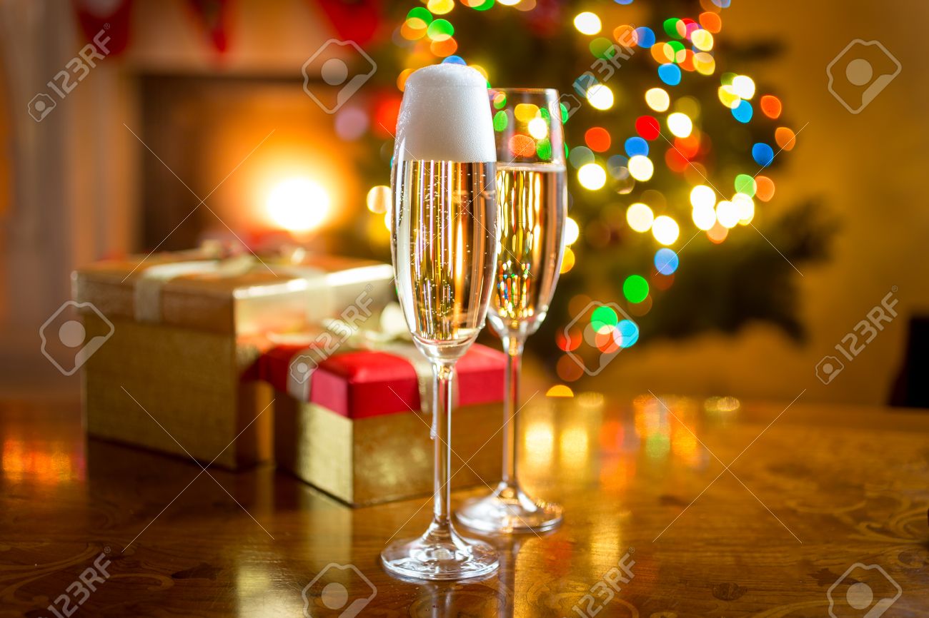 Two champagne glasses on table against fireplace decorated for Christmas - 45224695 Two champagne glasses on table against fireplace decorated for Christmas - 45224695