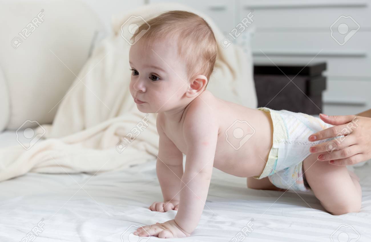Beau Bebe De 9 Mois En Couches Sur Le Lit Avec Des Draps Blancs Banque D Images Et Photos Libres De Droits Image