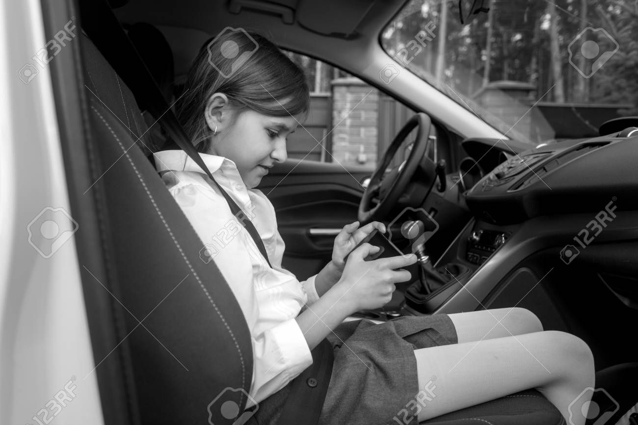 かわいい女の子の車に座って スマート フォンで遊んでの黒と白の肖像画 の写真素材 画像素材 Image かわいい女の子の車に座って スマート フォンで遊んでの黒と白の肖像画 の写真素材 画像素材 Image