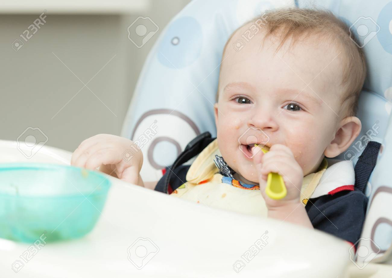 Adorable Nino De 9 Meses Comiendo En Silla Alta En La Cocina Fotos Retratos Imagenes Y Fotografia De Archivo Libres De Derecho Image