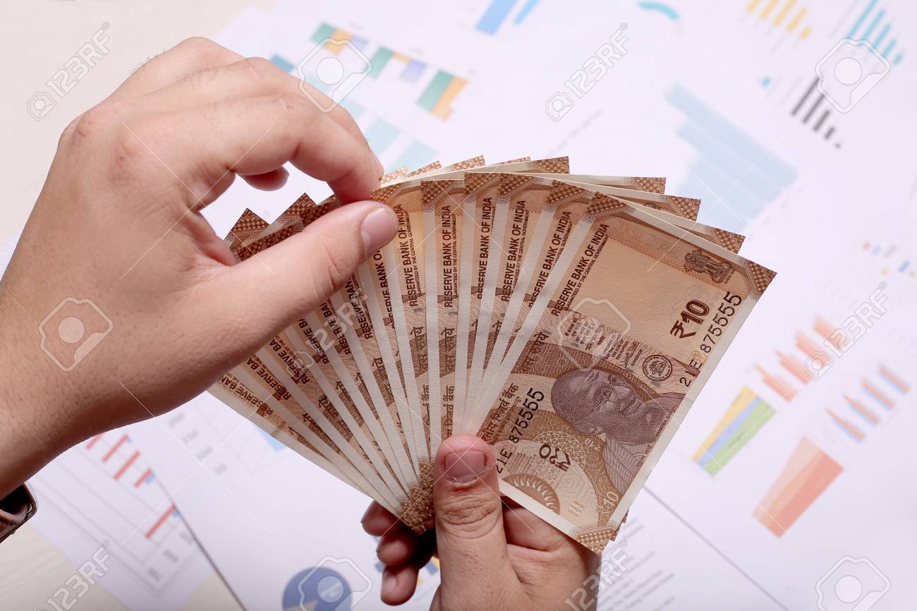 インド通貨の新しい10ルピー紙幣の広がりを示す手。の写真素材・画像素材 Image 108207568