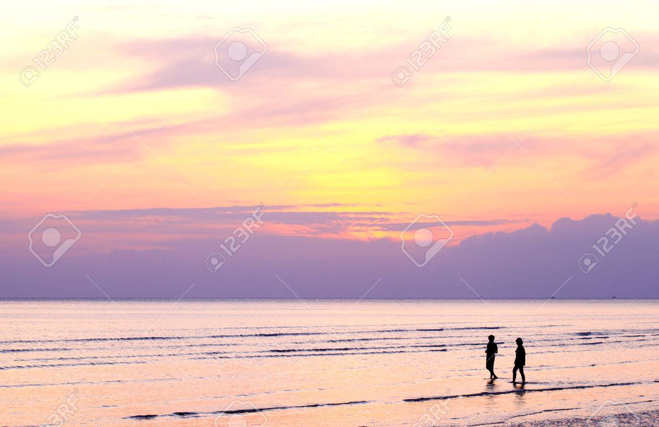 Silhouette Two People Walking Along The Beach When The Sun Sets. Stock  Photo, Picture and Royalty Free Image. Image 27542718., image size:1300x842