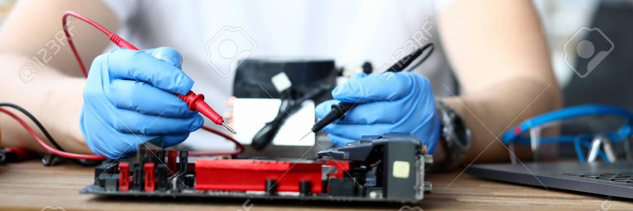 Close-up of male wearing protective blue gloves and using voltmeter on repairing detail. Middle-aged man measuring voltage. Technology and diy concept - 149848508 Close-up of male wearing protective blue gloves and using voltmeter on repairing detail. Middle-aged man measuring voltage. Technology and diy concept - 149848508